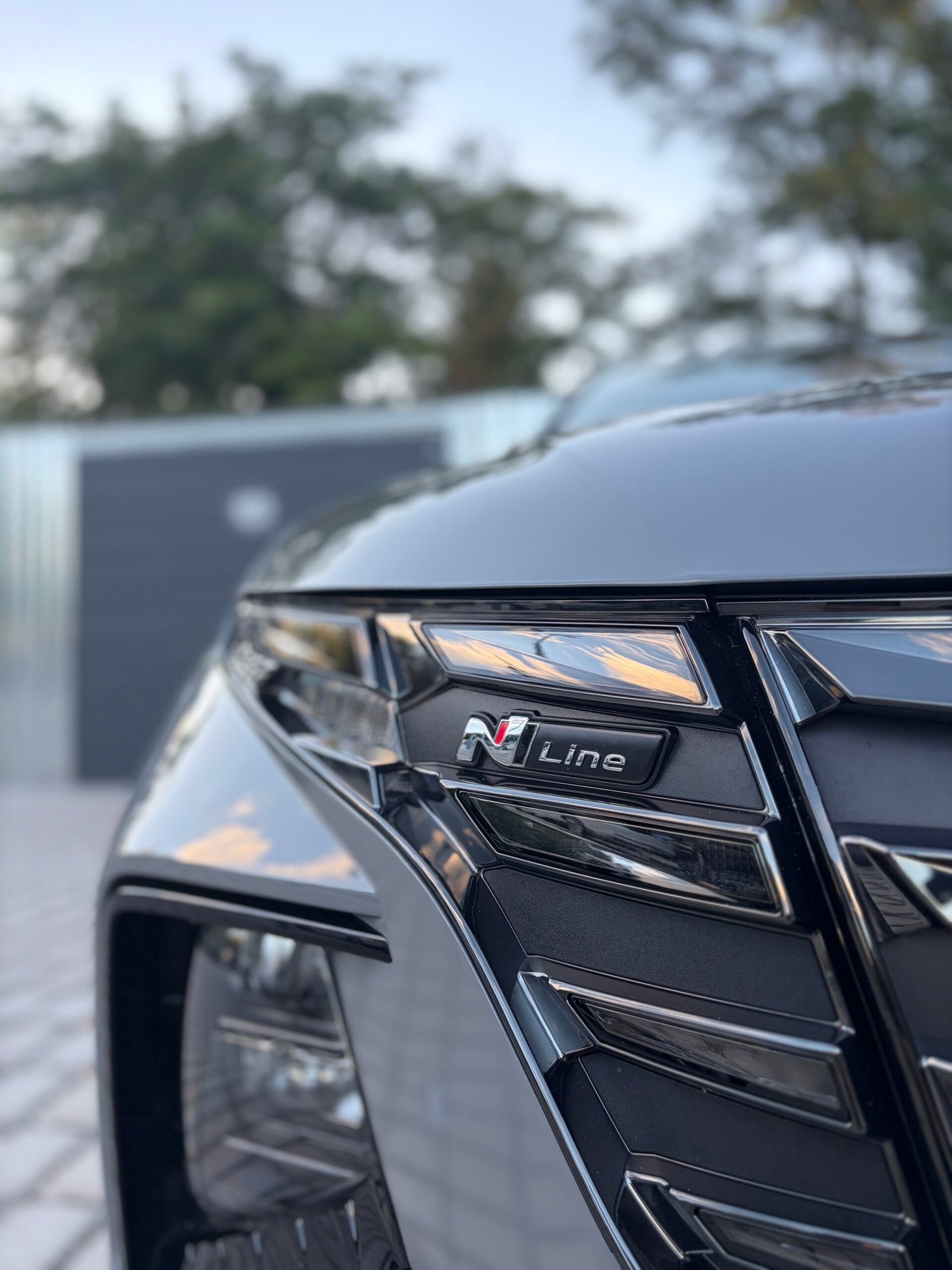 Detail masky a světlometu tmavého Hyundai s odznakem N Line po ošetření laku