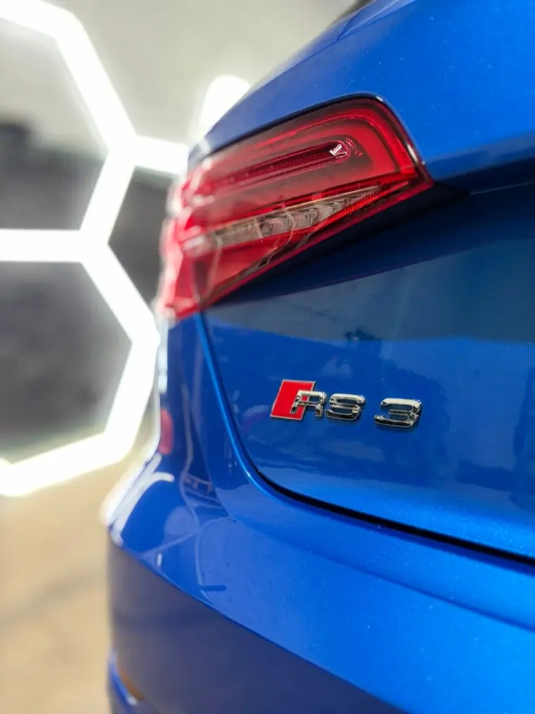 Detail zadního světla a znaku Audi RS3 v modré barvě po ošetření laku