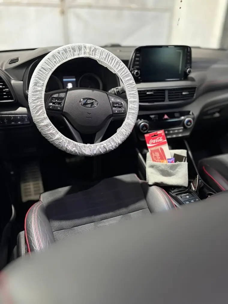 Interiér Hyundai po detailingu - palubní deska, displej a sedadla s červeným prošitím